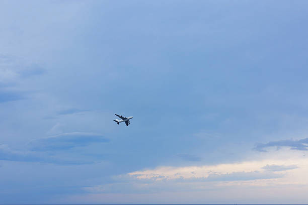 Airplane flying in beautiful blue sky, low angle view