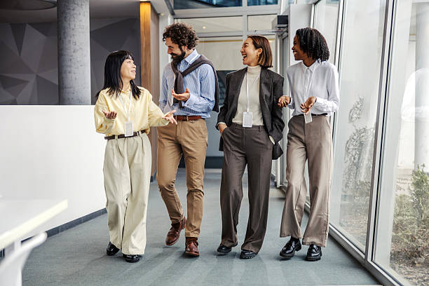istock Diverse business professionals walking, talking, and collaborating in office corridor 2252513643