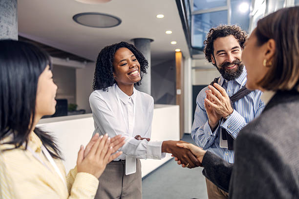 istock Businesswomen shaking hands in office while colleagues applauding 2252513668