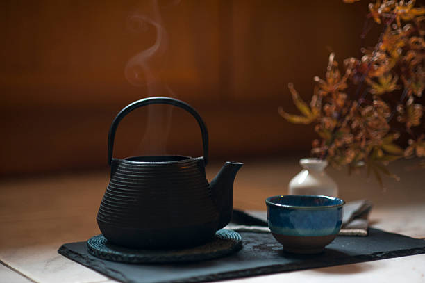 A traditional Japanese cast iron teapot with freshly brewed green tea. Authentic oriental tea set on a dark background, perfect for wellness, Zen, and healthy lifestyle concepts.