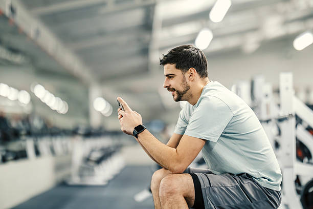istock Young adult man using phone during gym break 2252516268