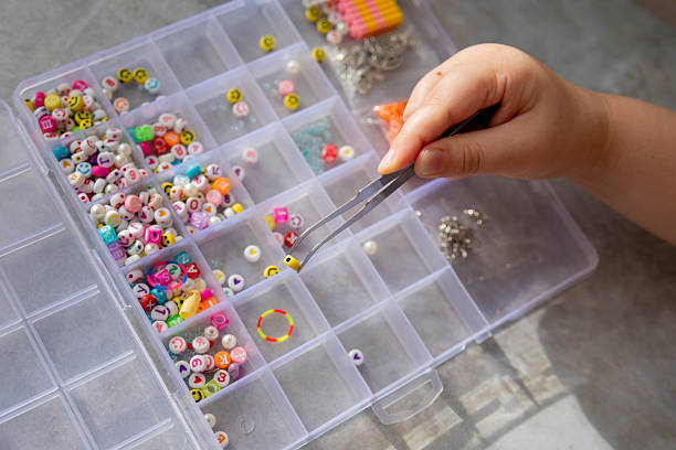 istock Making a bracelet from colored beads, children's hands close-up. 2252516367