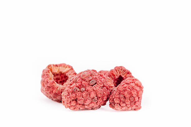 Freeze-dried raspberries are beautifully arranged on a pristine white background, highlighting their rich red hues and intricate textures,ideal for healthy snacks or culinary creations with copy space