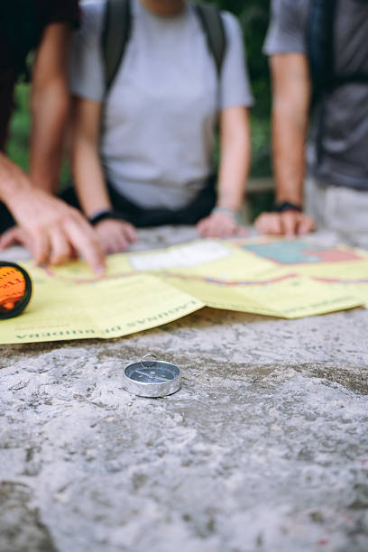 istock Hikers navigating route on map with compass outdoors 2252521315