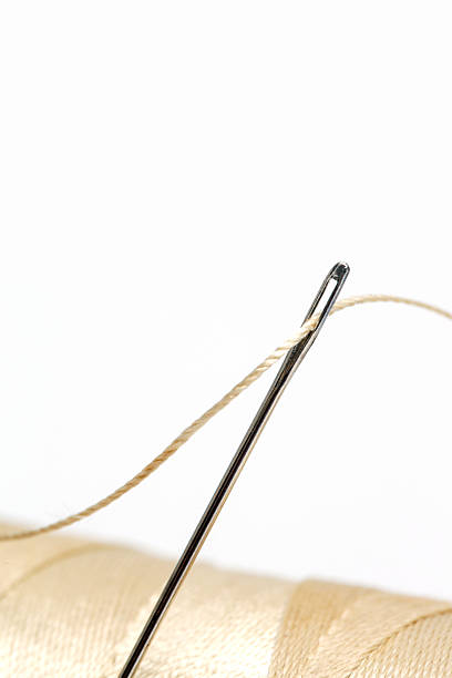 istock Close-Up of Thread and Sewing Needle on White Background, Minimal Tailoring and Craft Concept 2252523542