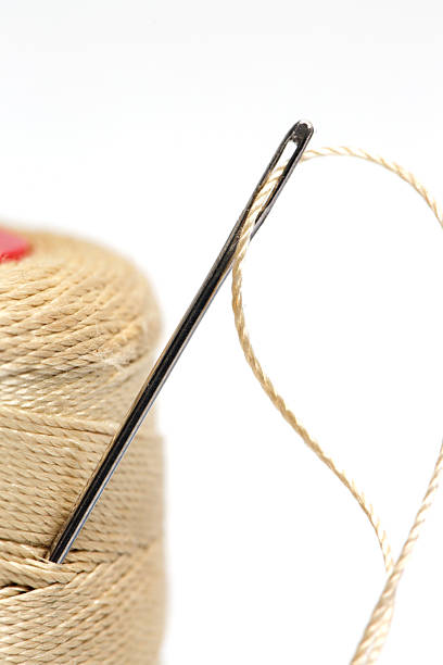 istock Close-Up of Thread and Sewing Needle on White Background, Minimal Tailoring and Craft Concept 2252523554