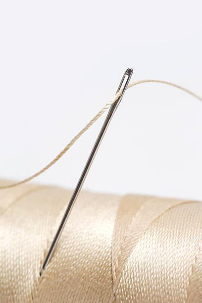 istock Close-Up of Thread and Sewing Needle on White Background, Minimal Tailoring and Craft Concept 2252523565