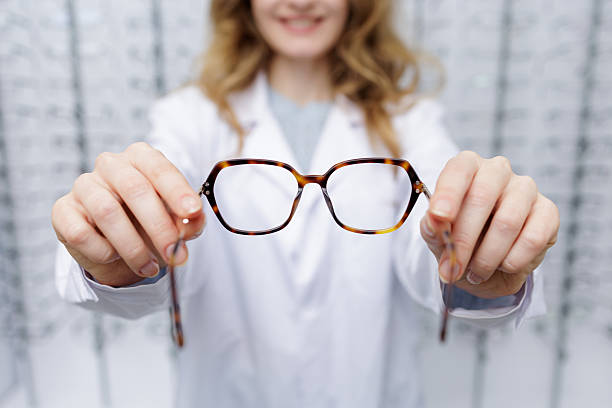 istock Optician presenting eyeglass frames to customer during prescription eyewear consultation 2252524137