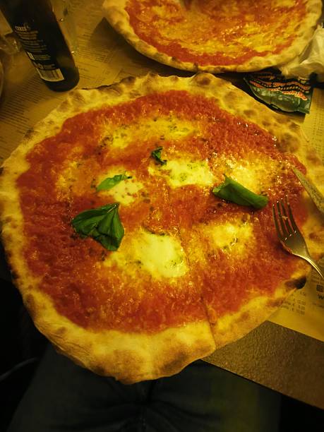 Enjoy the timeless taste of a classic Italian Margherita pizza. This masterpiece features a thin, crispy golden crust topped with rich tomato sauce, melted mozzarella cheese, and fresh green basil leaves. Perfectly baked in a traditional oven, it represents the simple yet extraordinary flavors of authentic Italian culinary heritage and tradition