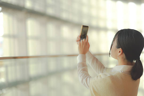istock Beautiful young woman using mobile phone at escalater 2252524634
