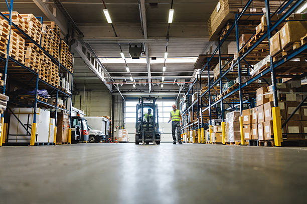 Forklift loader in Modern warehouse interior with shelves and boxes.