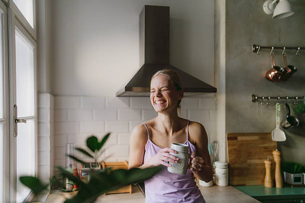 istock Young woman drinking tea in her kitchen 2252526168