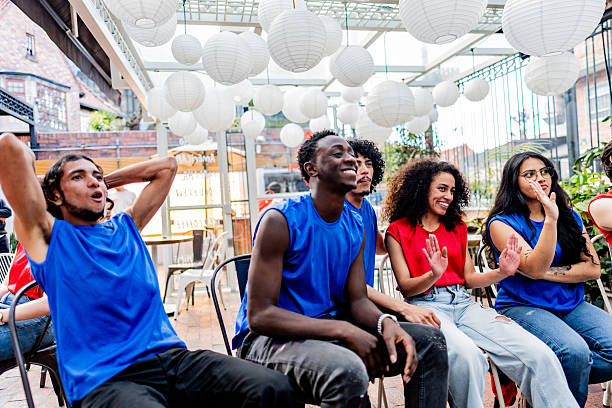 istock Friends cheering while watching a basketball match at the bar 2252527084