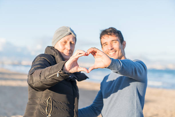 istock Mother and son forming heart shape on beach 2252527258