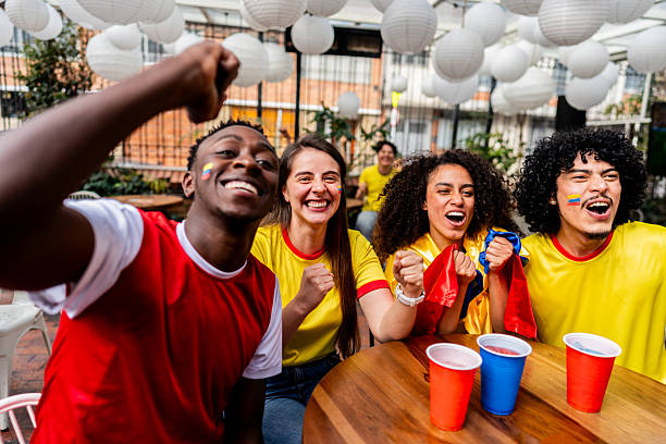 Friends cheering while watching a Colombia soccer match at the bar