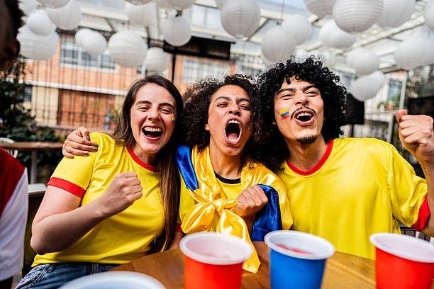 Friends cheering while watching a Colombia soccer match at the bar