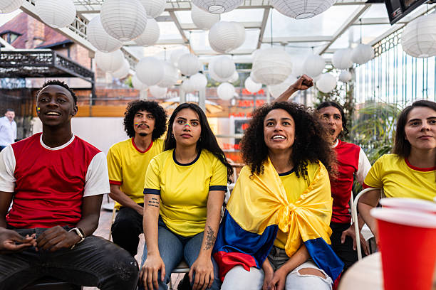 Friends cheering while watching a Colombia soccer match at the bar