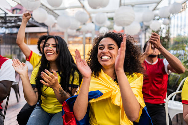 Friends cheering while watching a Colombia soccer match at the bar