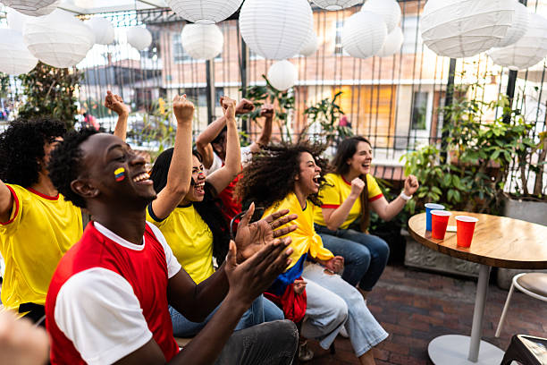 Friends cheering while watching a Colombia soccer match at the bar