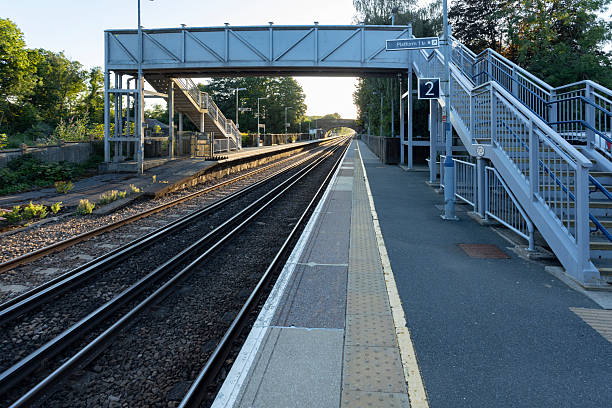 istock Elevated view of a quiet train platform with parallel tracks, a small station building, 2252535553