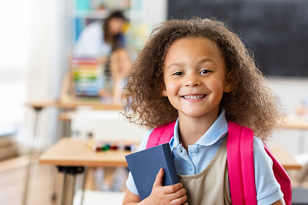 istock Happy young student with curly hair and a backpack, ready for school. 2252536676