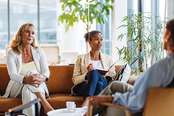 istock Businesswomen Conversing in Sunlit Office with Notepad 2252538416