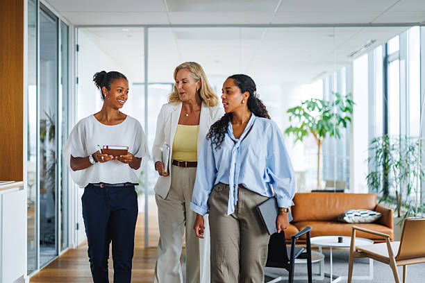 istock Engaged Businesswomen Discussing Ideas While Strolling in Office 2252538464