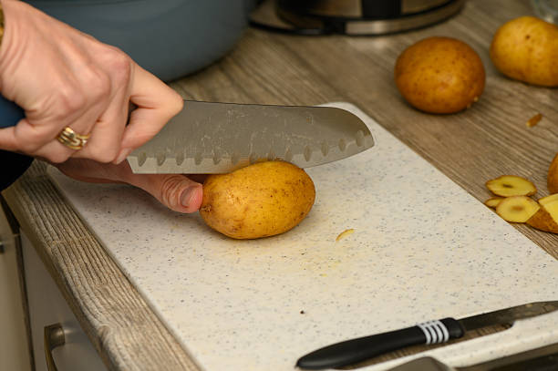 istock Chopping Raw Potatoes into Wedges on Cutting Board 2252540711