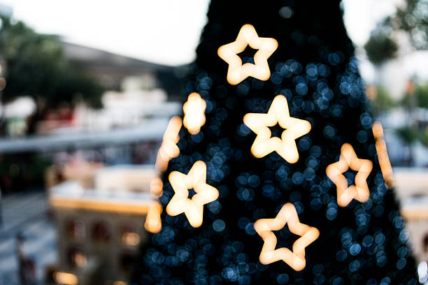 Blurred lights star shining amongst Christmas tree. Blurred Christmas tree with sparkle