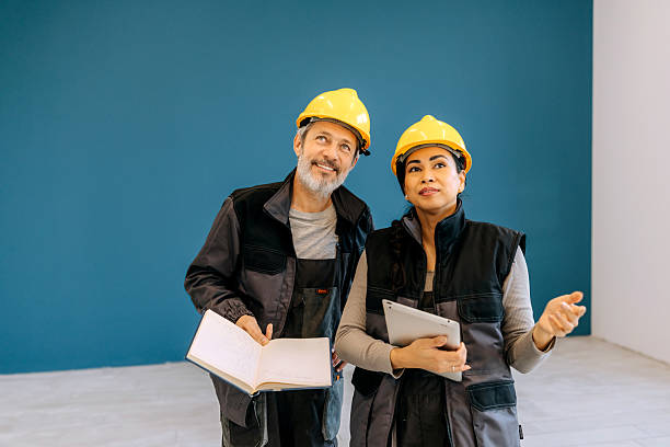 istock Male and female construction workers talking indoors 2252548070