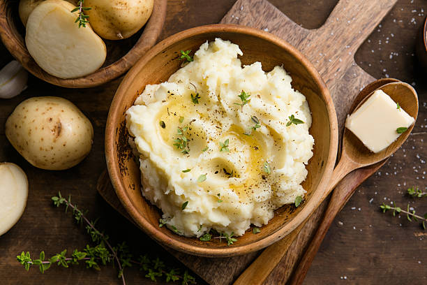 istock Mushed potatoes top view with raw potatoes and spices 2252552320