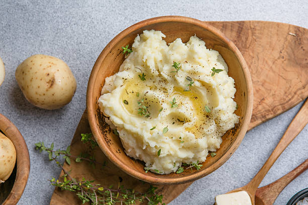 istock Mushed potatoes top view with raw potatoes and spices 2252552325