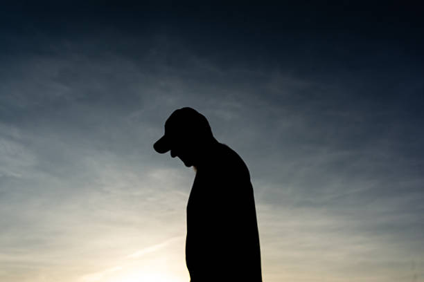 Salvador, Bahia, Brazil - December 12, 2025: An unidentified person in silhouette is seen walking near the Barra Lighthouse in Salvador, Bahia.