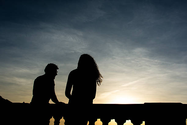 Salvador, Bahia, Brazil - December 12, 2025: The silhouette of two people is seen walking during sunset at Barra beach in Salvador, Bahia.