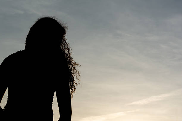 Salvador, Bahia, Brazil - December 12, 2025: An unidentified person in silhouette is seen walking near the Barra Lighthouse in Salvador, Bahia.