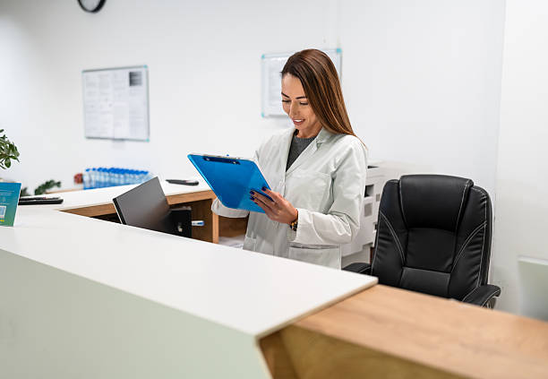istock Professional woman in lab coat holding clipboard at reception 2252557888