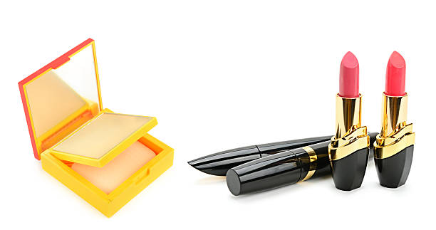 A clean composition of pink lipsticks, black mascara tubes, and a yellow compact powder case. This isolated setup on a white background includes ample copy space for beauty branding and ads.