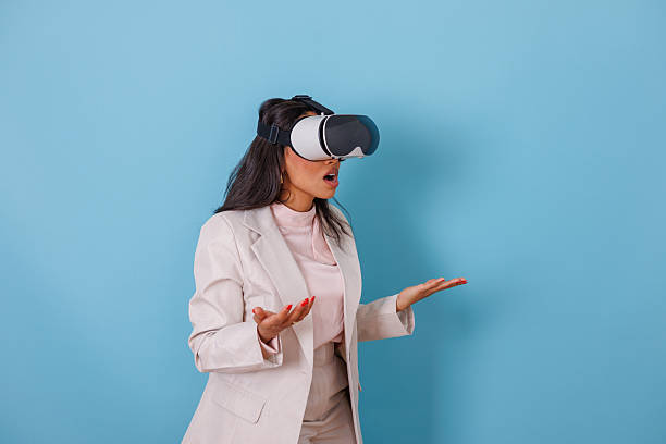 istock Young adult woman wearing vr headset seeing 3d simulation. She is surprised and impressed by the virtual world 2252562995