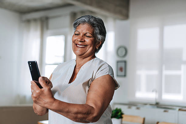 istock Smiling Senior Woman Using Smartphone At Home 2252563222
