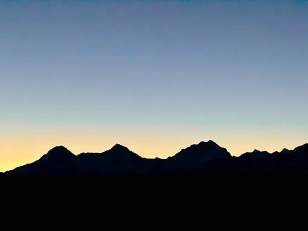 Eiger Monch and Jungfrau at sunrise, dark silhouettes, clear sky