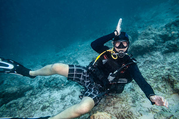 istock Diver making a funny pose underwater in the Maldives, exploring the coral reef while scuba diving on a tropical vacation 2252565897