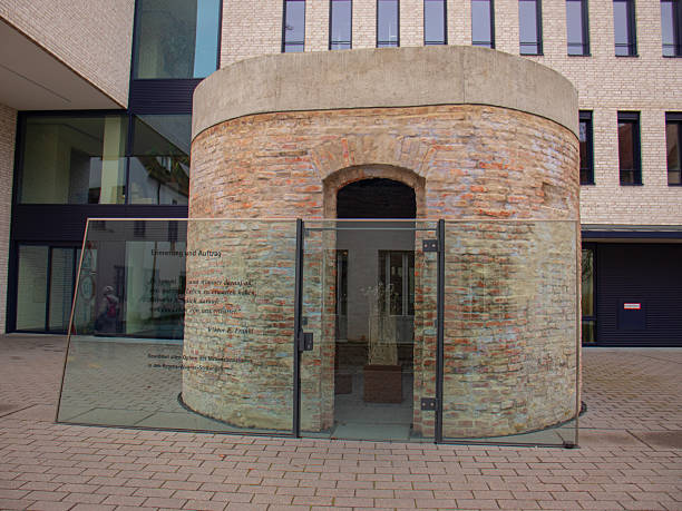 memorial, a circular brick structure protected by glass panels with an inscription dedicated to victims of National Socialism, located in a modern urban square, 30, 2025, at Dillingen, Bavaria, Germany.