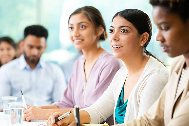 istock Diverse group of people actively engaged in a learning or discussion session, attentively listening and taking notes. 2252568289