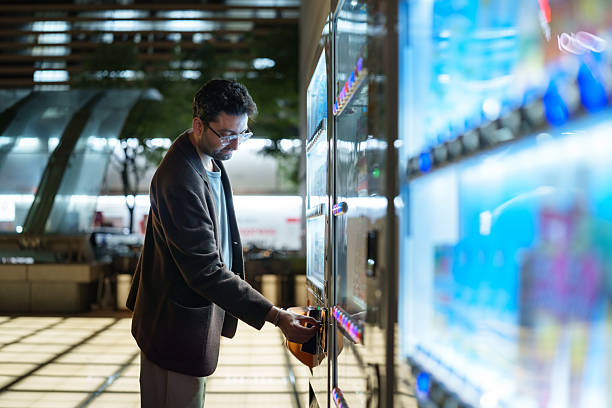 istock Man Using a Vending Machine at Night in the City 2252569122