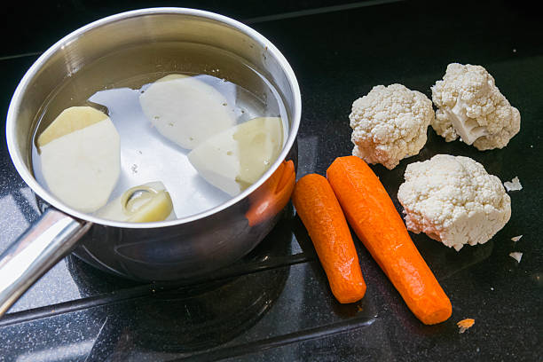 Freshly chopped vegetables on a black granite counter waiting to be added to a pan of water as part of a healthy meal