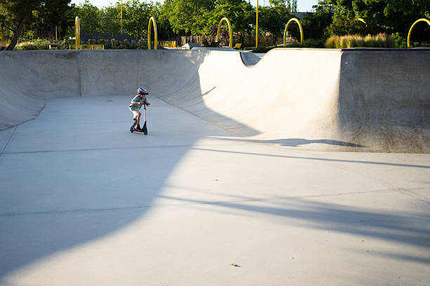 istock Child riding a scooter in a skate park having fun 2252573703