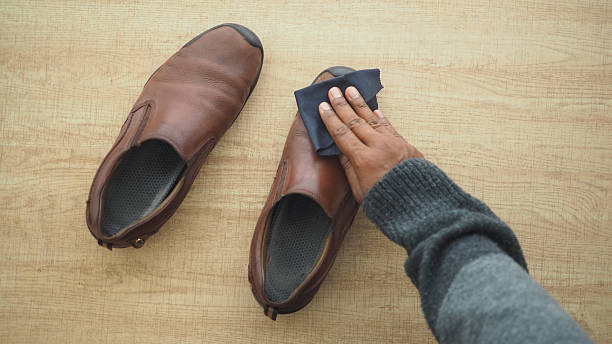 istock Cleaning brown shoes on a wooden surface in daylight 2252576775
