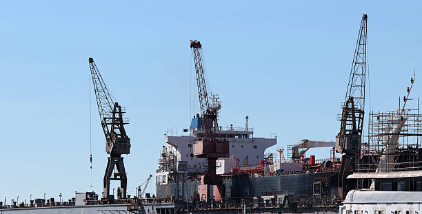 istock Industrial harbor with cargo ship and dock cranes, maritime logistics and shipyard infrastructure under clear blue sky 2252577523