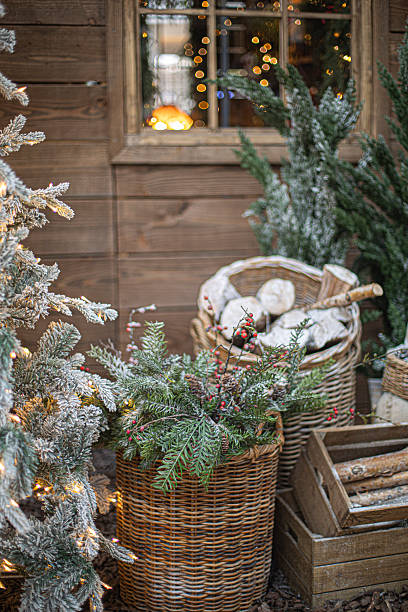 istock Christmas tree decorated with pine cones, basket with firewood 2252579905