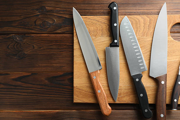 istock Many different knives and board on wooden table, top view. Space for text 2252592510